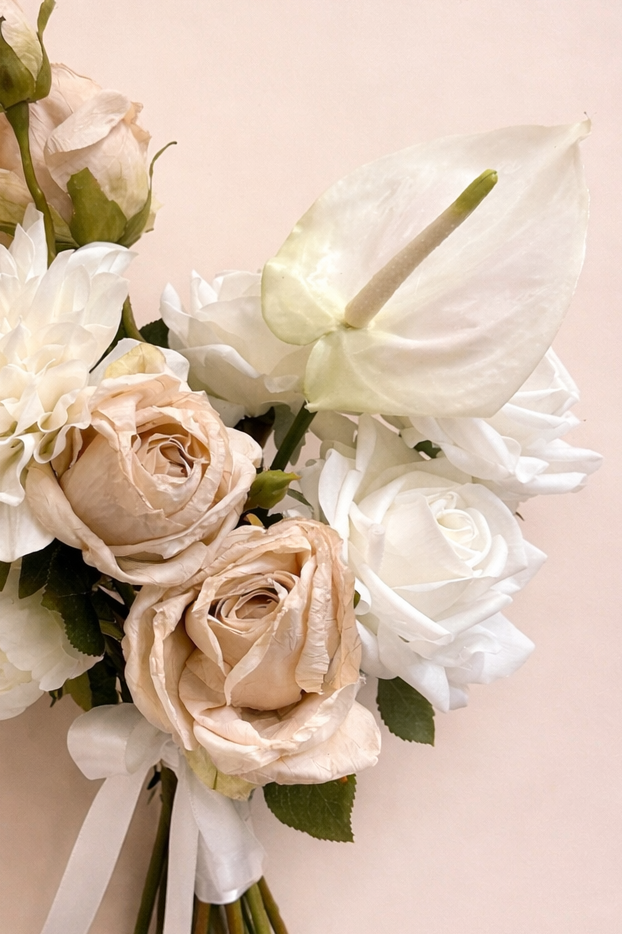 Close-up of nude rose, creamy dahlia and peony flowers in an artificial bridal bouquet