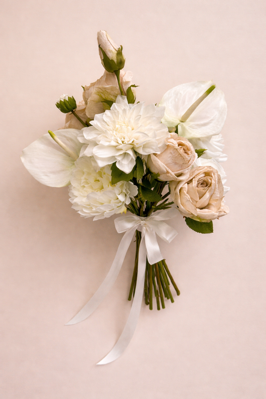 Nude and cream artificial bridal bouquet featuring roses, dahlias and peonies on a neutral background
